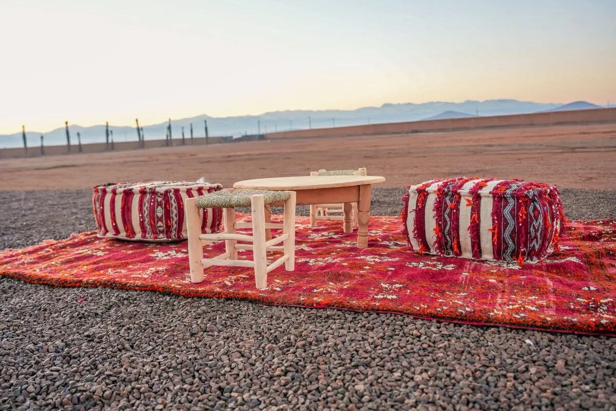 Moroccan seating with poufs and carpet in the desert at sunrise
